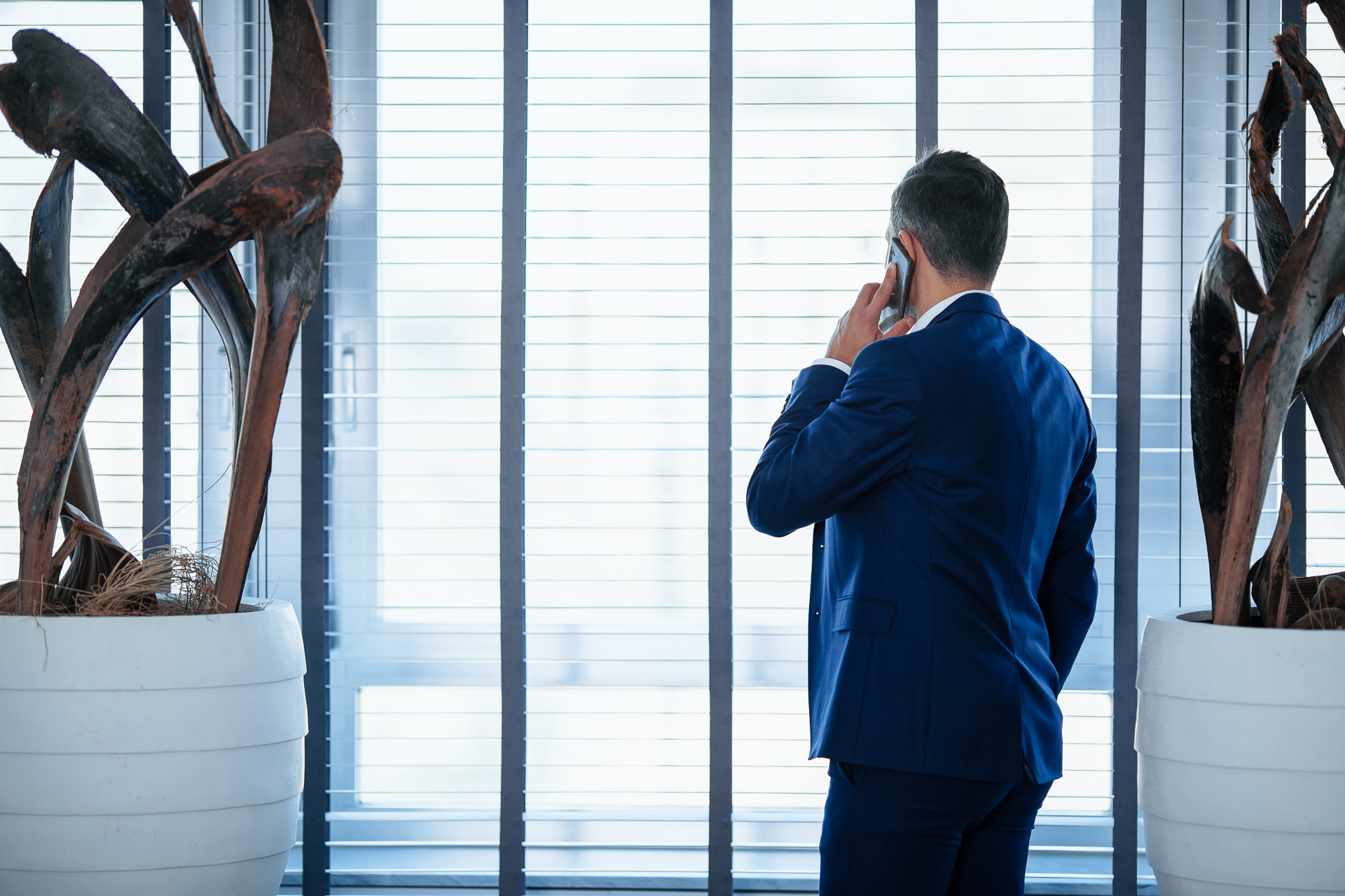 Mann telefoniert am Fenster im WCH Büro